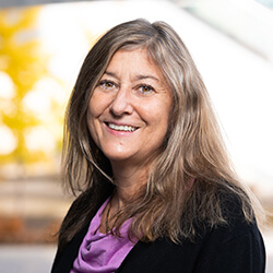 Headshot of Lynn Macdonald, Ph.D. wearing a purple shirt