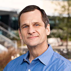 Headshot of William Olson, Ph.D. wearing a green shirt