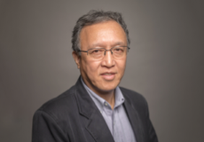 Headshot of Ron Wang, PhD wearing a grey shirt