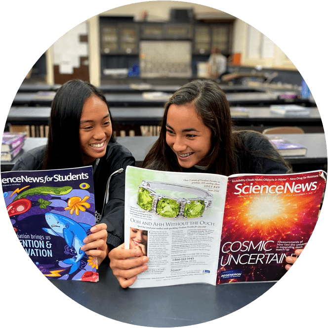 Two students reading scientific textbooks at a table.