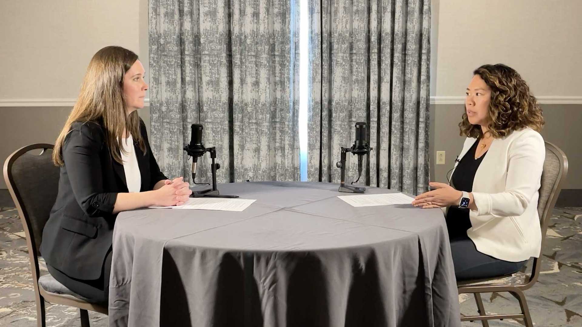 Two people speaking on a podcast