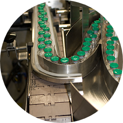 Close-up of vials running through an assembly line.