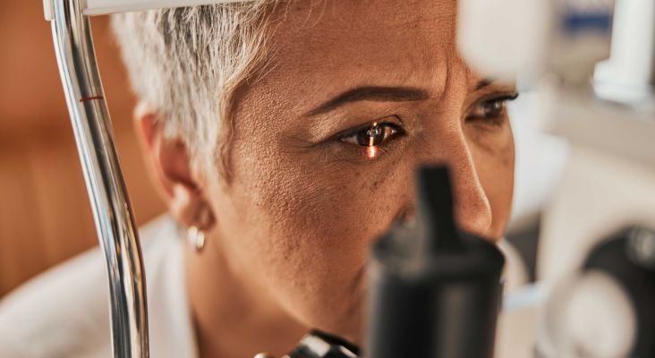Close-up of a person receiving an eye examination with medical equipment