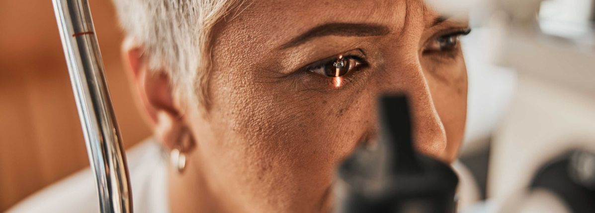 Close-up of a person receiving an eye examination with medical equipment