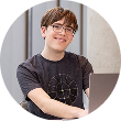  Connor Hill smiling while working on a laptop