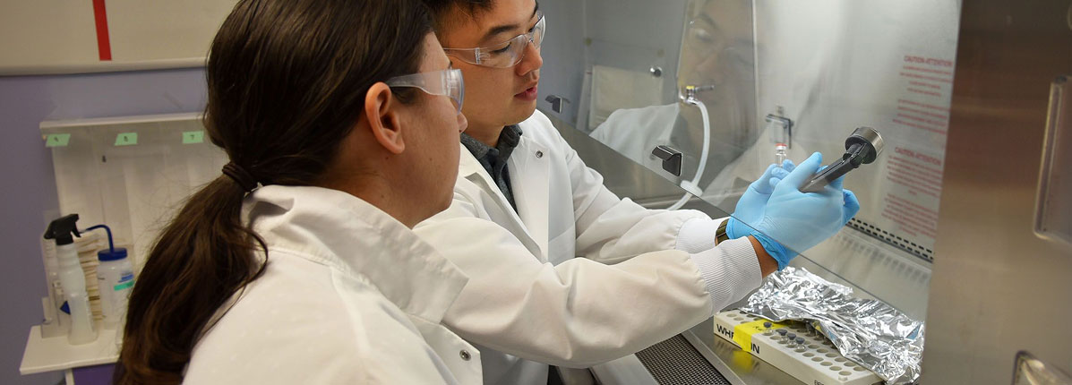 A scientist storing supplies in a temperature controlled compartment