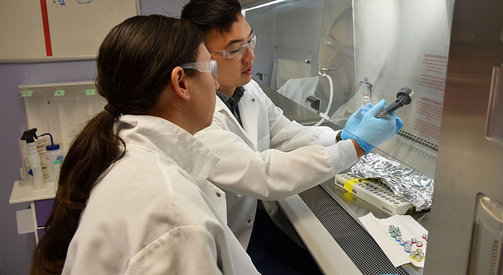 A scientist storing supplies in a temperature controlled compartment