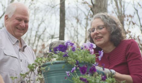  Linda smiling with her husband while they garden